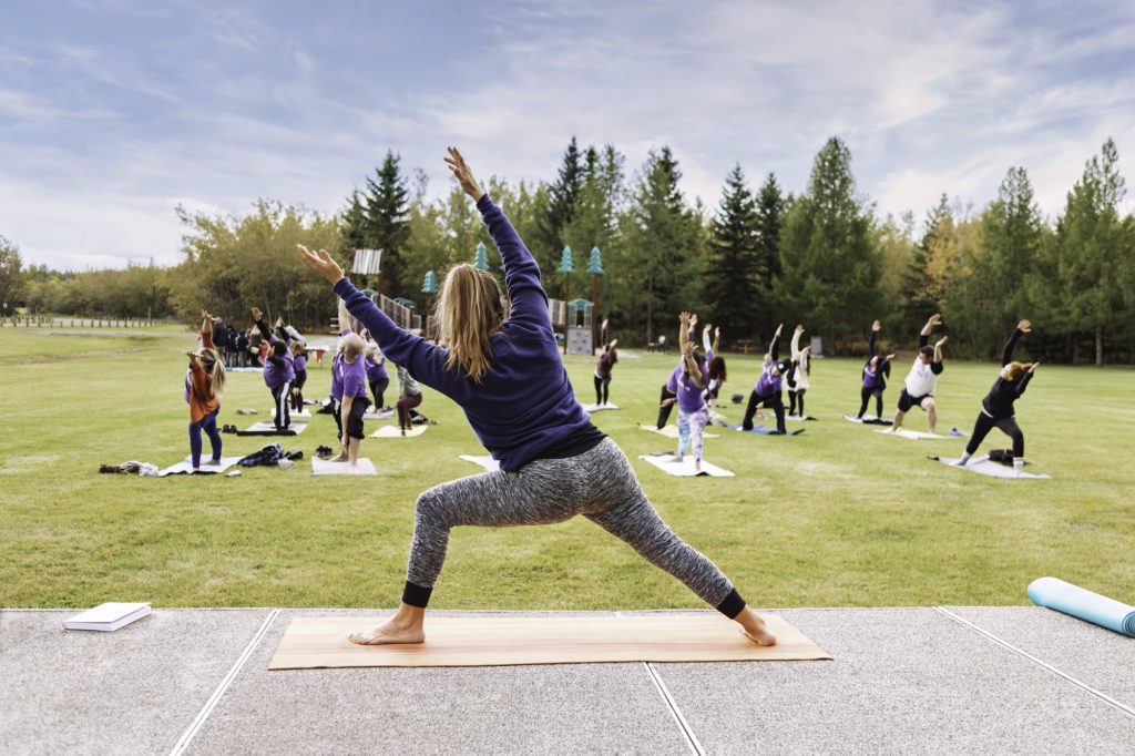 Outdoor Yoga classes. Group of adults attending yoga classes in the park.